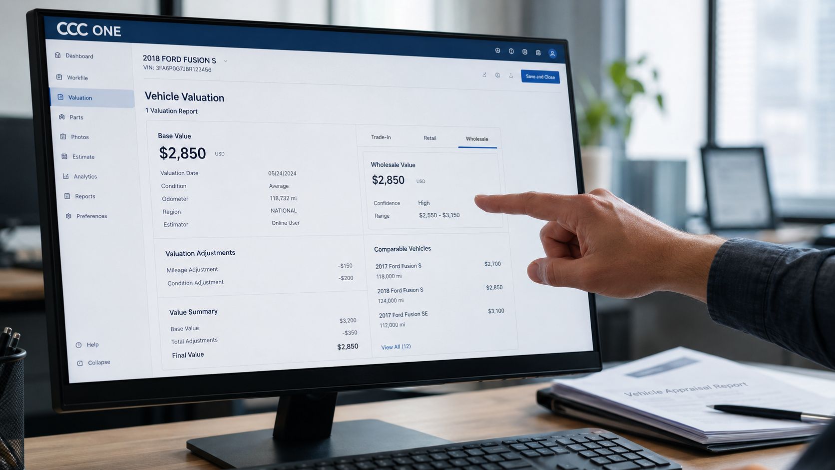 A professional analyzing a vehicle valuation report for a 2018 Ford Fusion on a computer monitor.